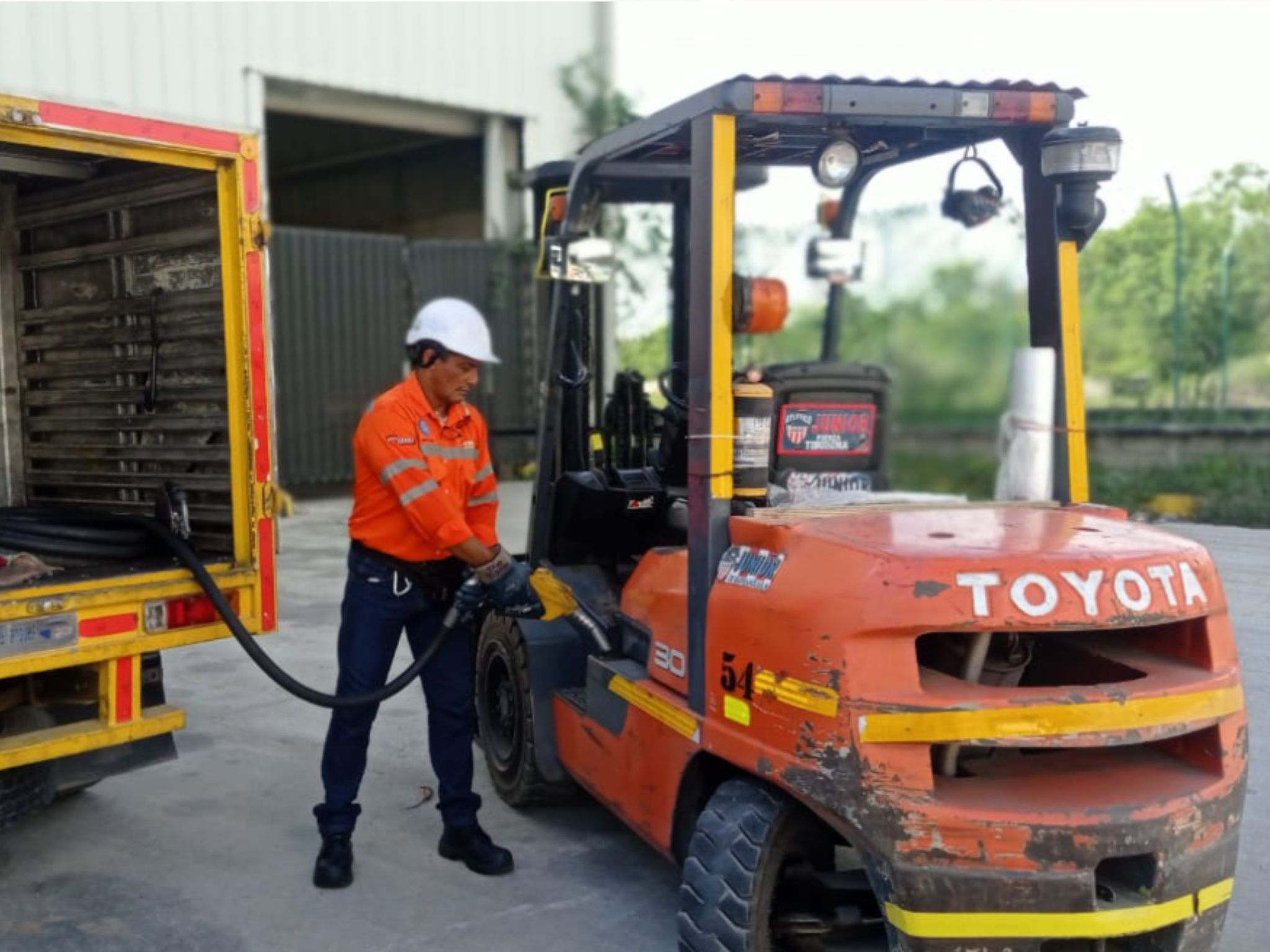Operario de Dino Montacargas suministrando combustible de Dino Fuels al montacargas en alquiler en Barranquilla.