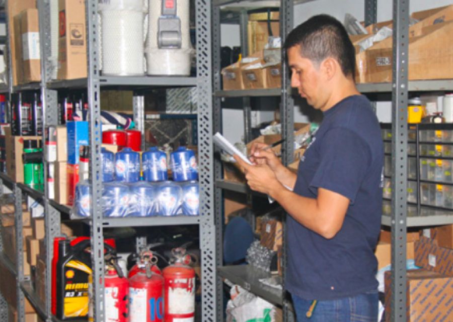 Almacenista de GRUPO GLM verificando el inventario de la empresa logística.